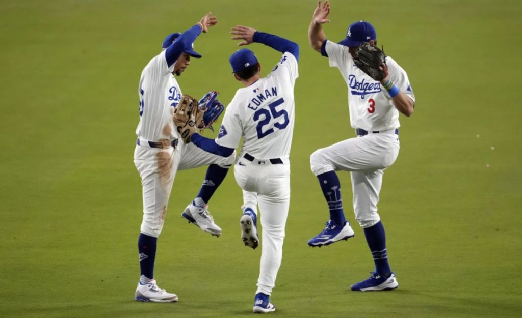 Chris Taylor (3), Tommy Edman (25) y Mookie Betts, de los Dodgers de Los Ángeles, celebran después del segundo juego de la Serie Mundial de béisbol contra los Yankees de Nueva York, el sábado 26 de octubre de 2024, en Los Ángeles. Los Dodgers ganaron 4-2. (Foto AP/Julio Cortez)